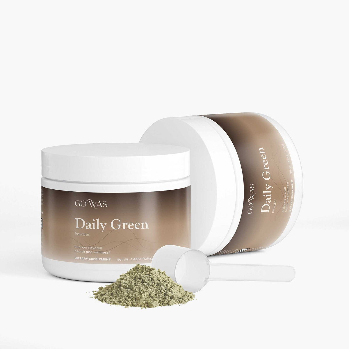 Daily Greens powdered supplement in a brown-and-white tub, with a scoop and a pile of green powder