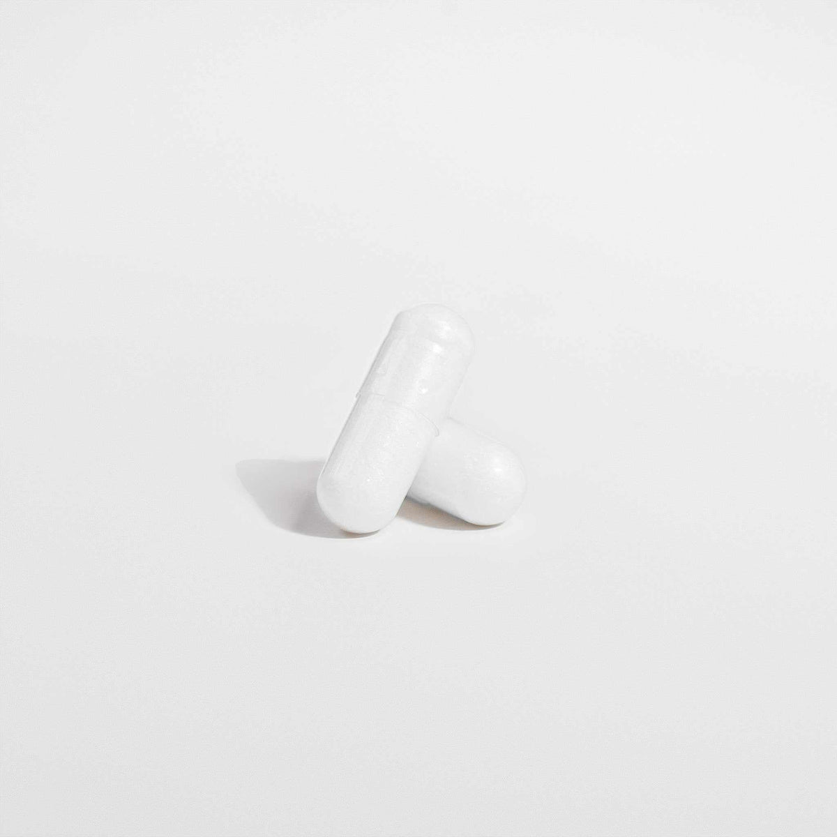 Magnesium Sleep Ritual supplement capsules in smooth white capsules with a simple, solid finish.