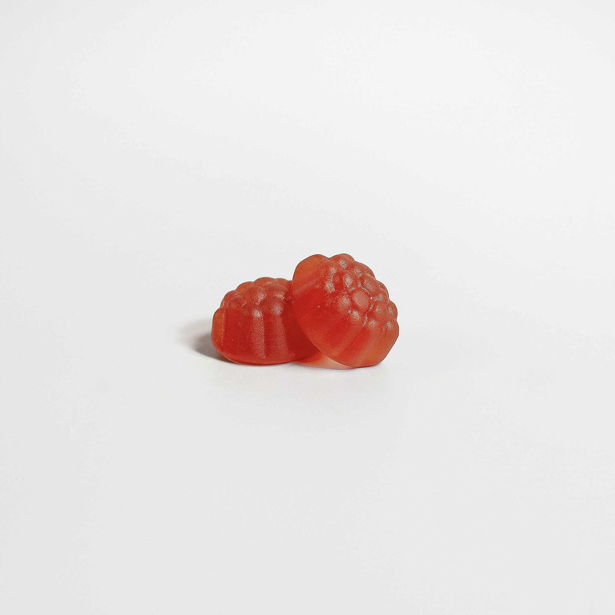 Sleep & Calm gummy supplement in translucent red-orange berry-shaped pieces with a glossy, textured surface
